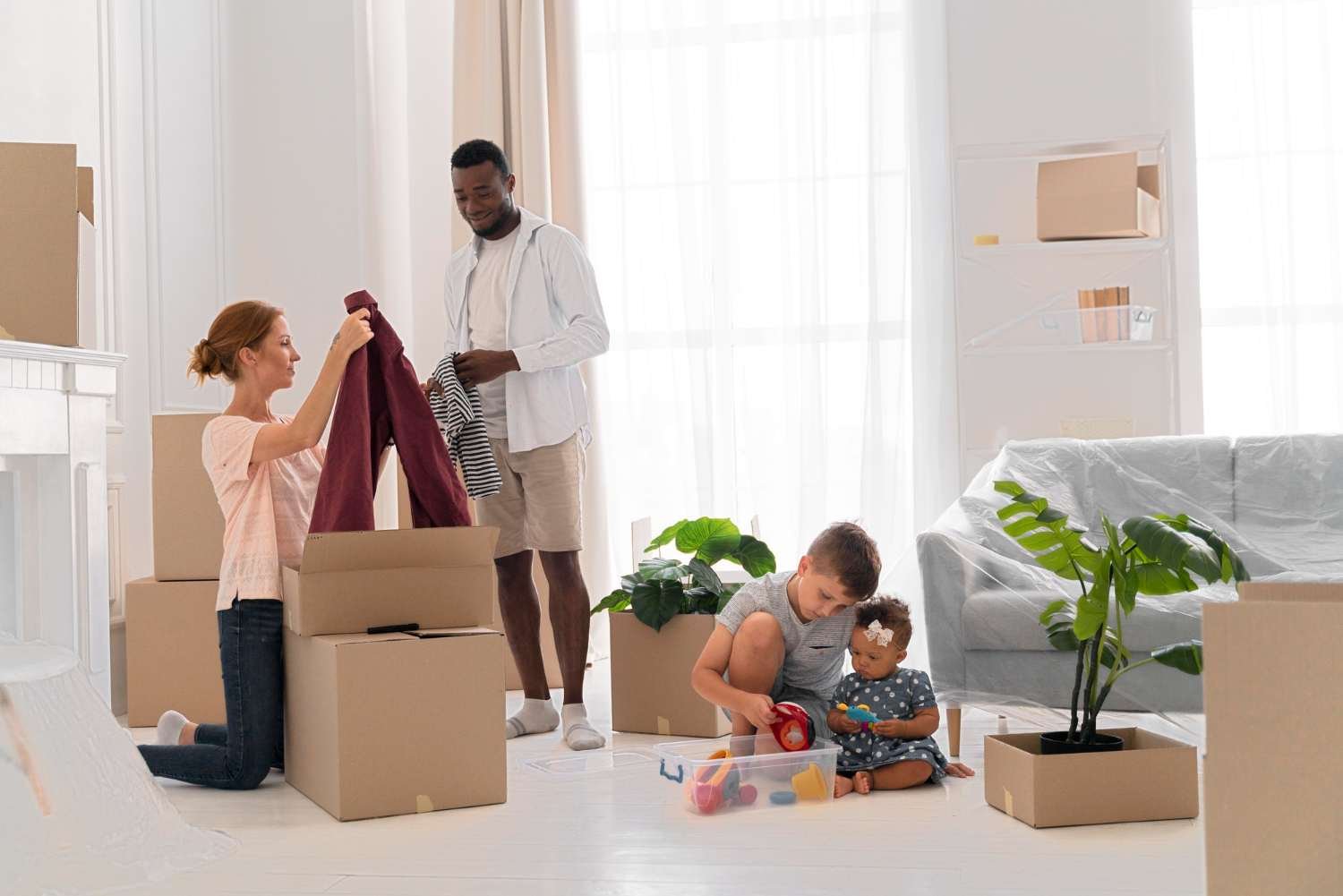 family of four packing or unpacking moving boxes